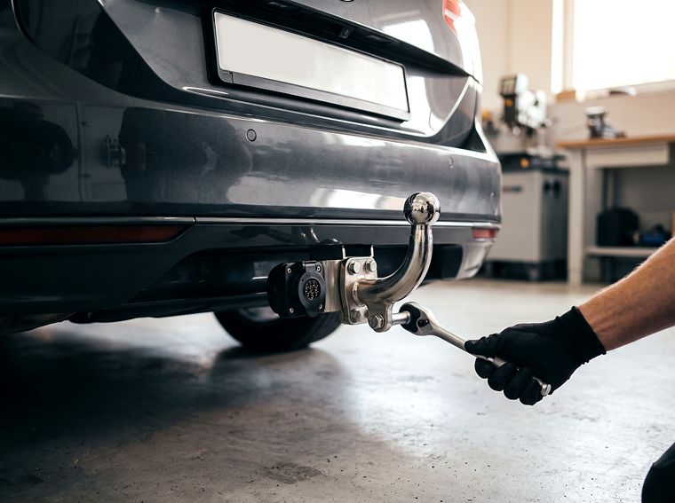 Tow bar being fitted to the rear of a car